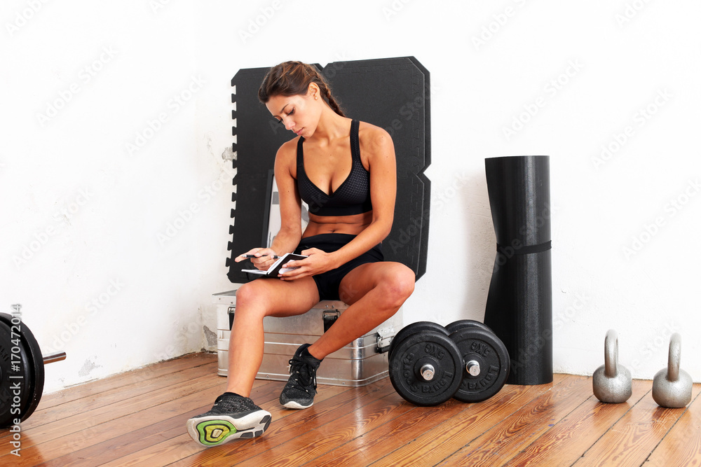 Naklejka premium hübsche Sportlerin mit Trainingsplan im GYM