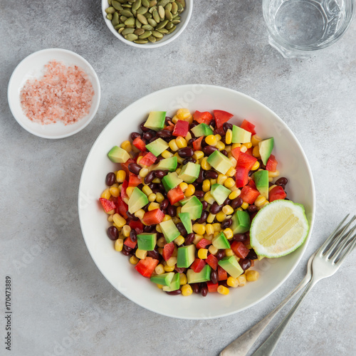 Avocado, black bean, corn and bell pepper salad in white bowl