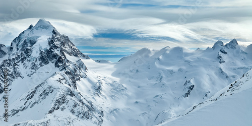Winter snowy mountain with bizarre clouds panoramic view from Corvatsch peak of the Lower Engadine, in the Switzerland. photo