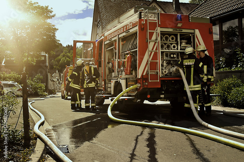 Feuerwehreinsatz mit Feuerwehrleuten und Feuerwehrfahrzeug