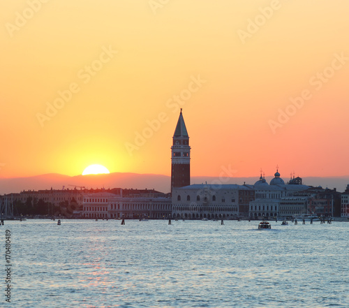 Sun at SUNSET in VENICE in Italy and the Campanile of St. Mark