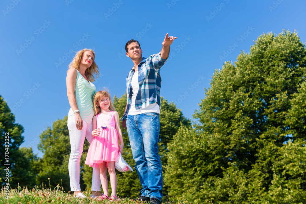 Mommy, daughter standing at edge of woods, Daddy is telling the way Mommy, daughter standing at edge of woods, Daddy is telling the way