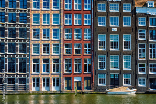  houses and boat on Amsterdam canal Damrak with reflection. Ams