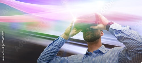 Composite image of low angle view of man using virtual reality