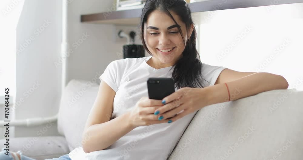 Beautiful Girl Use Cell Smart Phone Sitting On Coach In Living Room Happy Smiling Young Woman Chatting Online At Home Slow Motion 60 Beautiful Girl Use Cell Smart Phone Sitting On Coach In Living Room Happy Smiling Young Woman Chatting Online At Home Slow Motion 60