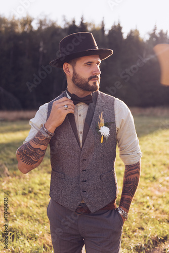 Portrait of stylish beard, male with tattoos on his arms. Wedding portrait