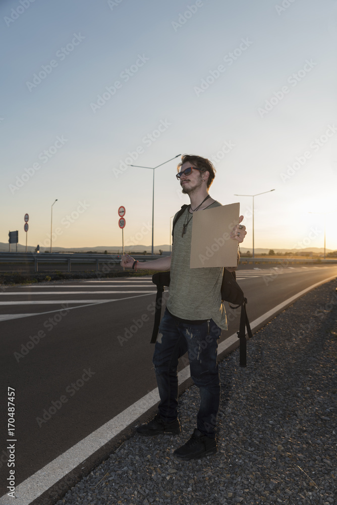 21 years old man hitchhiking on a highway 21 years old man hitchhiking on a highway