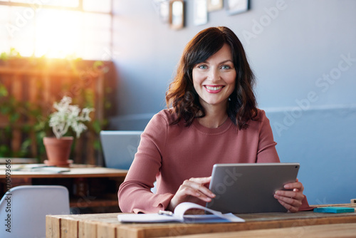 Smiling young businesswoman hard at work in a modern office