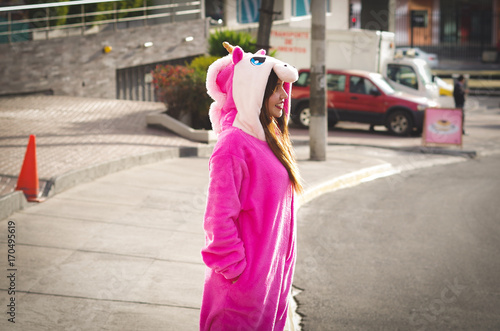 Close up of a beautiful smiling young woman wearing an unicorn costume, at outdoors in the city of Quito