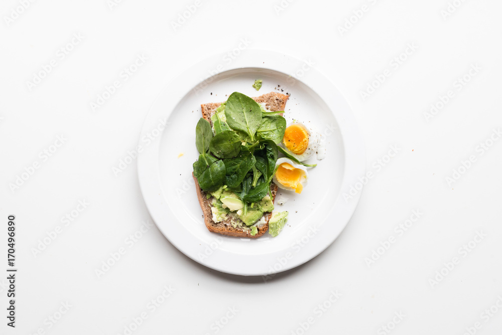 High angle view of smashed avocado, spinach on toast with boiled egg High angle view of smashed avocado, spinach on toast with boiled egg