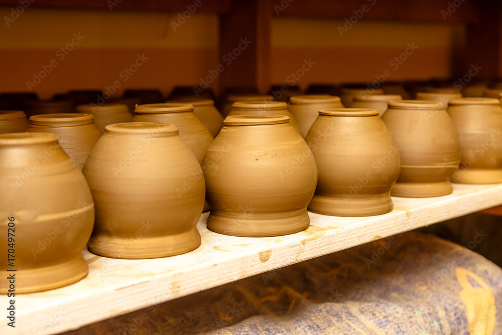 A pottery. Pots and jars without a pattern are on the shelves.