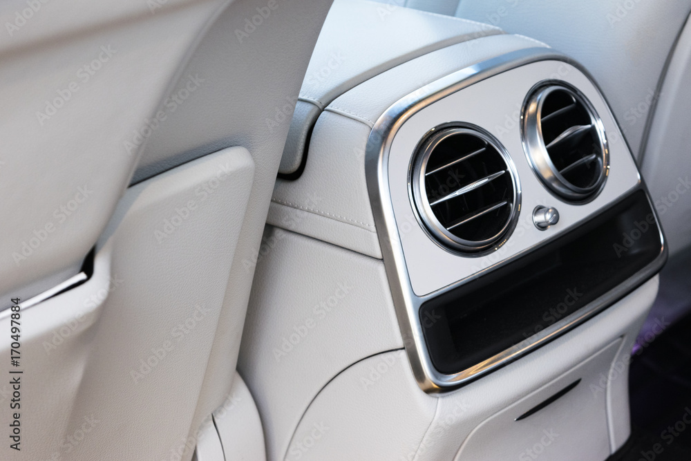 AC Ventilation Deck Luxury Car Interior. Modern car interior details white leather, natural wood.