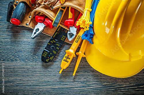 Building helmet leather tool belt on wooden board electricity co