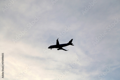 Plane silhouette on a cloudy sky. 