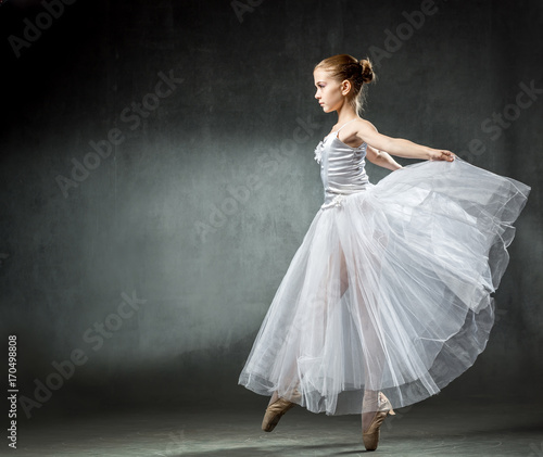 Ballet. Image of a flexible cute ballerina dancing in the studio. Beautiful young dancer. A ballerina is posing.