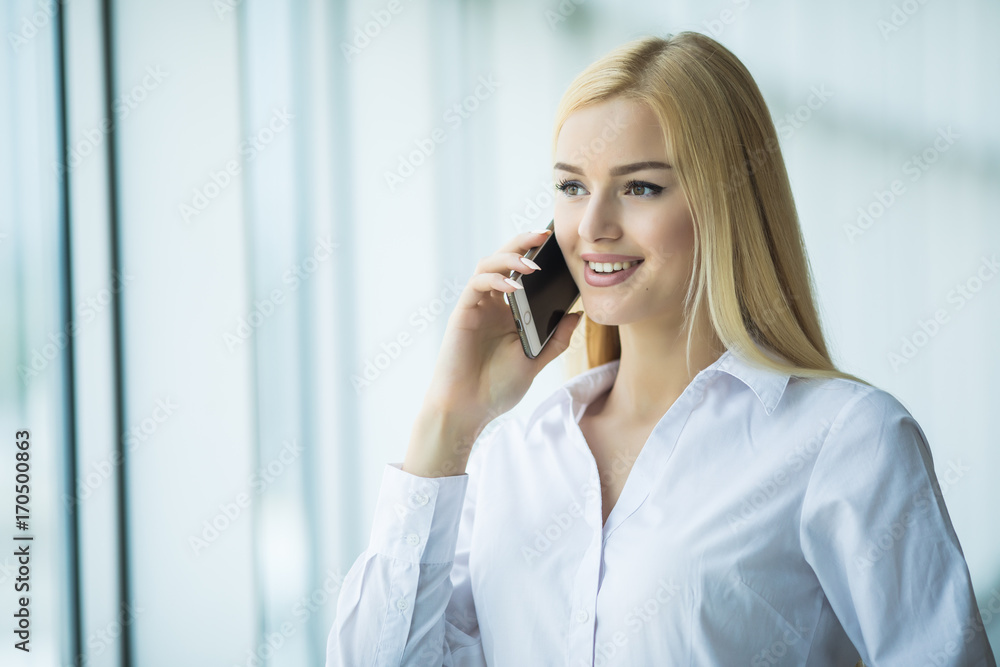 Smart business woman talking by mobile phone in office Smart business woman talking by mobile phone in office