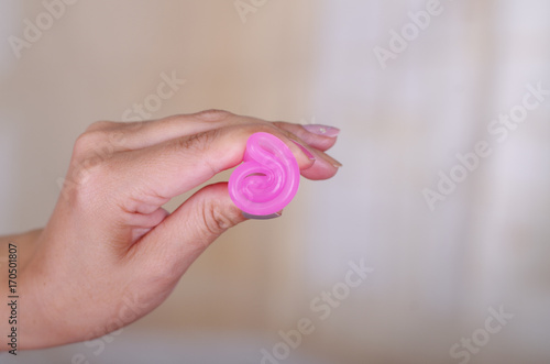 Close up of woman hand holding menstrual cup  in a blurred background
