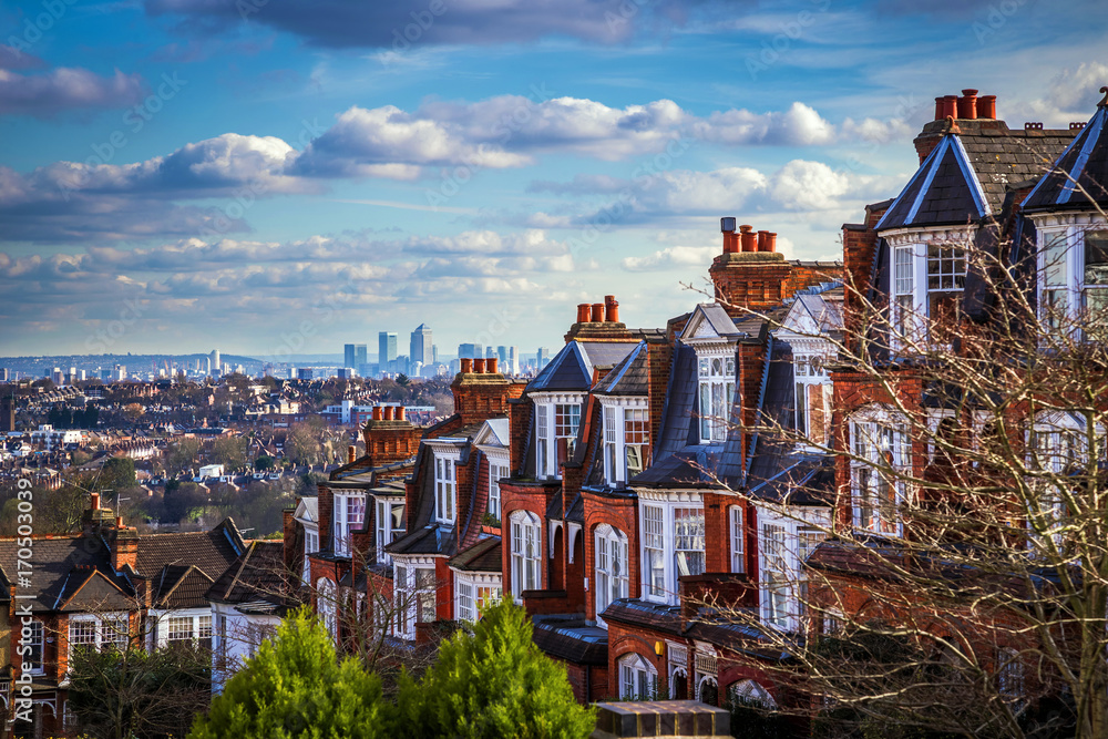 London, England - Panoramic skyline view of London and the skyscrapers of Canary Wharf with traditional British brick houses