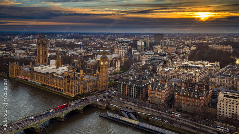 London, England - Aerial skyline view of the Big Ben and Houses of Parliament, Westminster Bridge with red double decker buses, St Margaret's Church, St James's Park and Buckingham Palace at sunset