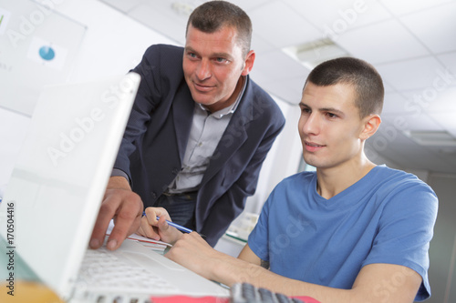 a man teacher and a student girl with a computer