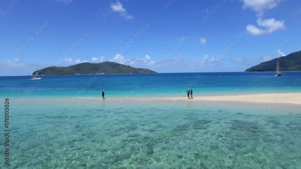 A wide aerial shot of a sand bay and ocean with people A wide aerial shot of a sand bay and ocean with people
