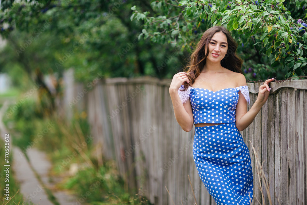 Fashion portrait of young pretty trendy girl in vintage dress posing in the countryside Fashion portrait of young pretty trendy girl in vintage dress posing in the countryside