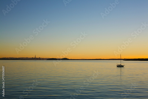 Golden and orange light closes the day over Auckland and the serene Waitemata Habour  New Zealand