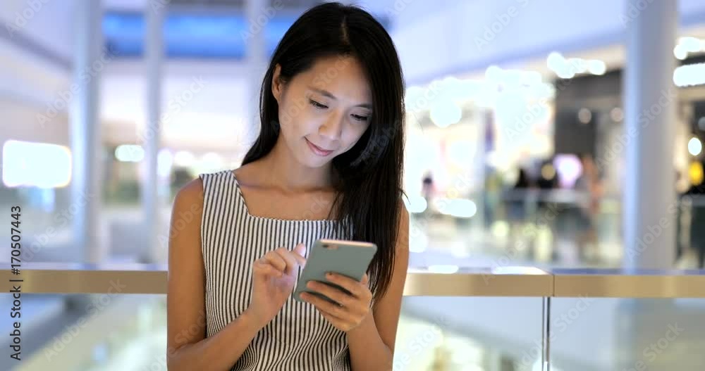 Woman looking at mobile phone inside shopping mall Woman looking at mobile phone inside shopping mall