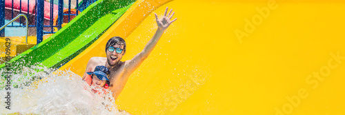 BANNER Father and son on a water slide in the water park Long Format