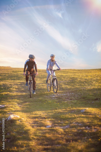 Happy mountainbike couple outdoors have fun together on a summer afternoon