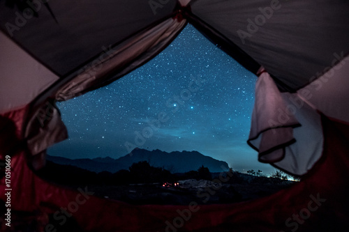 Romantic starry sky night view from inside of tent.  Camp with spectacular starry sky wtih mountain background.