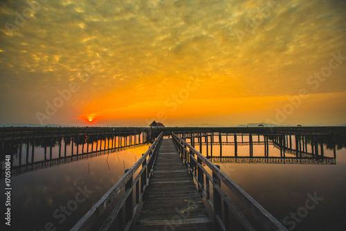 Beautiful romantic golden sunset and wooden bridge at pond. Fantastic vivid twilight at Sam Roi Yod National Park  Prachuap Khirikhan  Thailand.