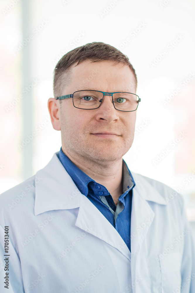 Portrait of confident mature male surgeon standing arms crossed in hospital Portrait of confident mature male surgeon standing arms crossed in hospital