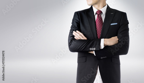 Business concept - confident modern business man with dark suit , stand and think the business plan, isolated on grey background.