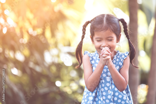 Canvas-taulu Cute asian little child girl praying with folded her hand for faith,spirituality