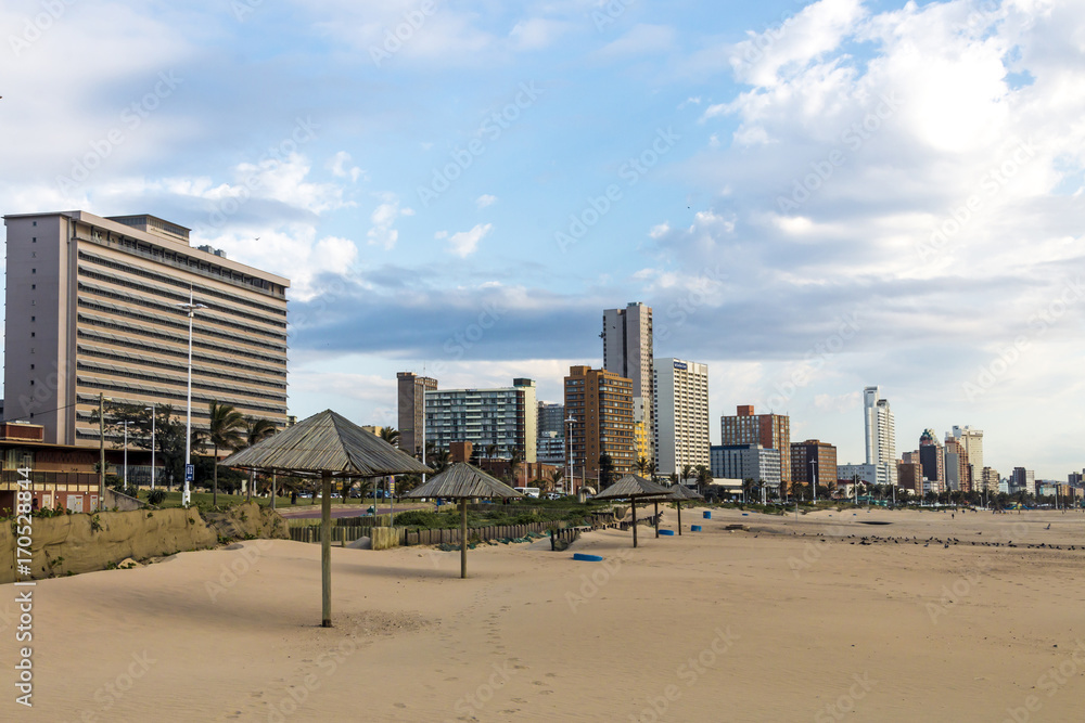 Early Morning Beach Against City and Blue Cloudy Skyline