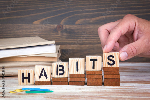 Habits concept. Wooden letters on the office desk, informative and communication background.