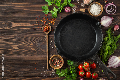 herbs and spices around cast iron skillet photo