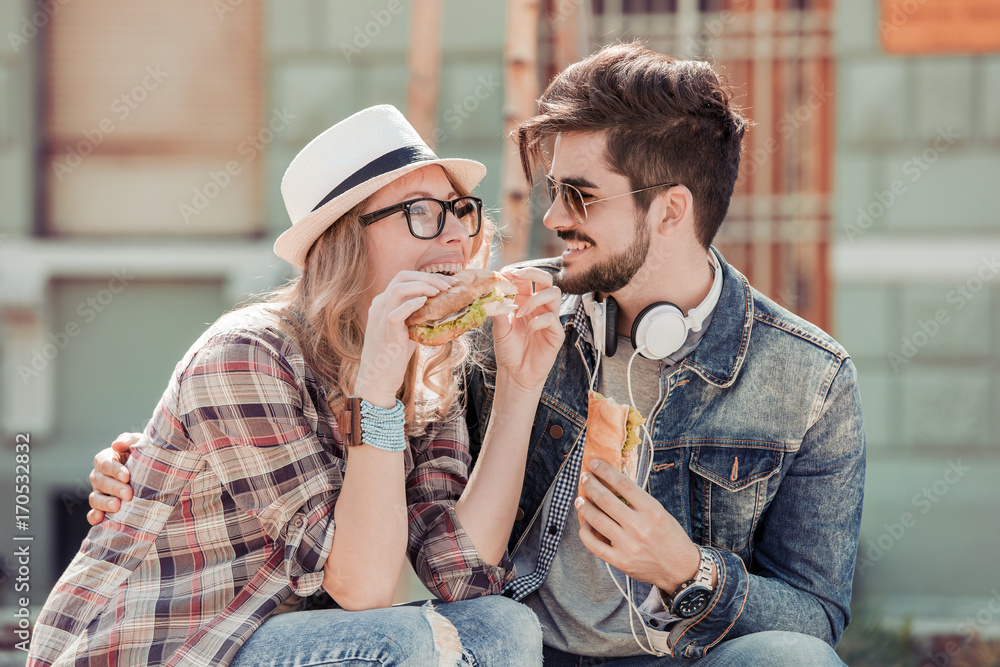 Young happy couple eating together outdoors. Young happy couple eating together outdoors.