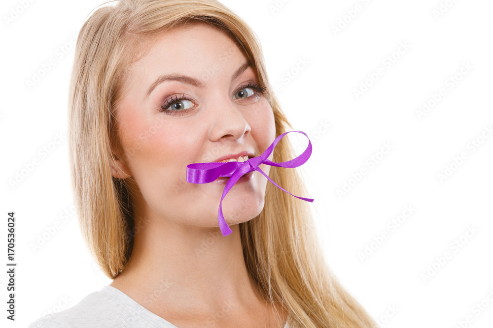 Blonde woman biting decorative purple bow Blonde woman biting decorative purple bow