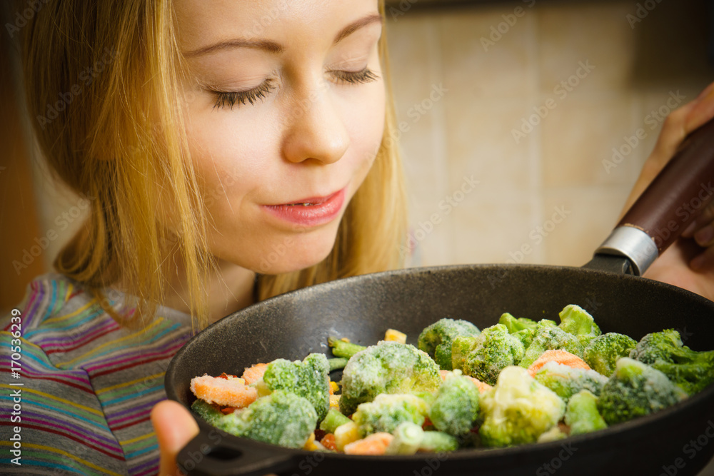 Woman cooking stir fry frozen vegetable on pan Woman cooking stir fry frozen vegetable on pan