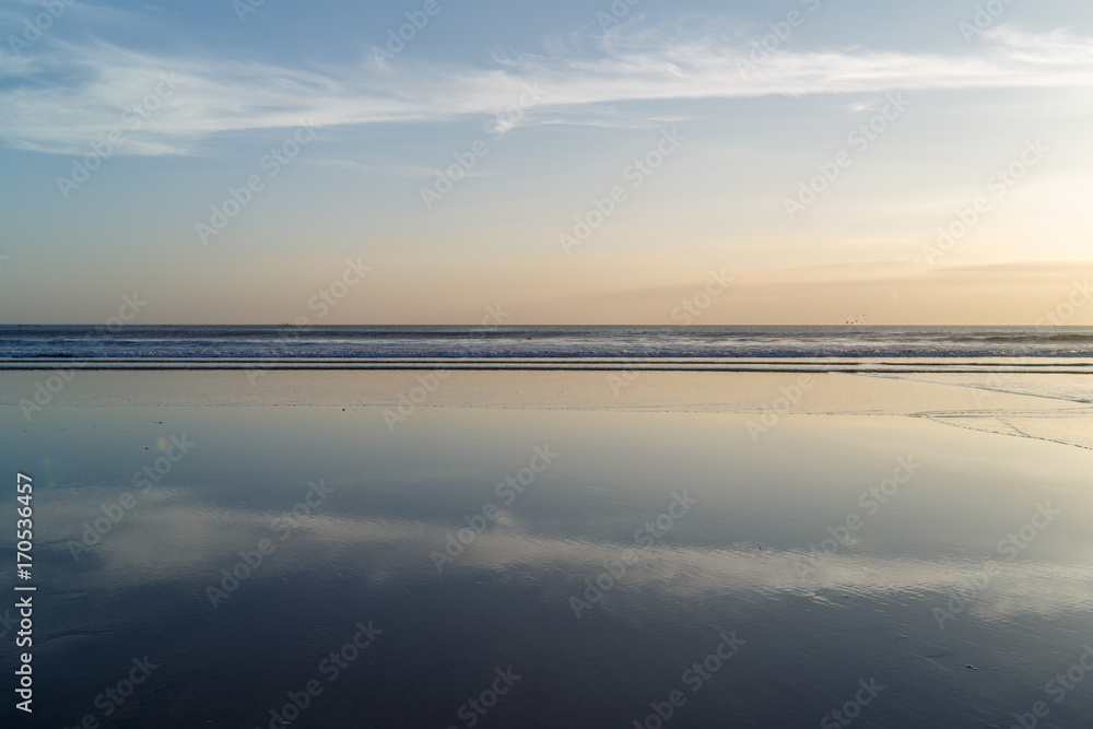 Sunset at Cuta Beach, Bali with beautiful mirror reflection