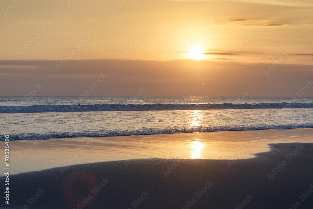Golden sunset on the tropical beach. Cuta beach on Bali island. Indonesia