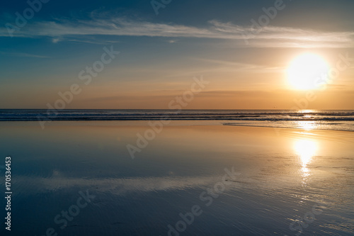 Sunset at Cuta Beach, Bali with beautiful mirror reflection