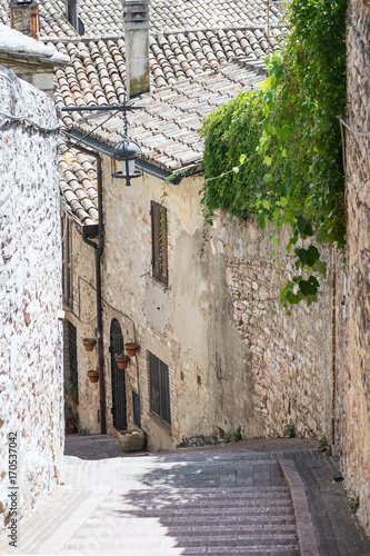 The picturesque old medieval Assisi street with stairs leading down