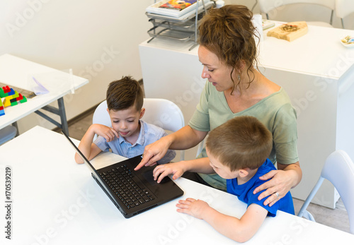 teacher woman learn to use laptop two preschooler boy in the classroom © dobok