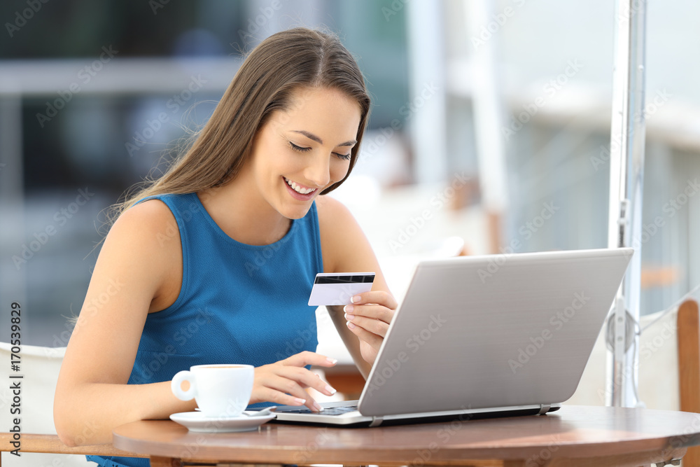 Happy buyer buying on line in a bar Happy buyer buying on line in a bar