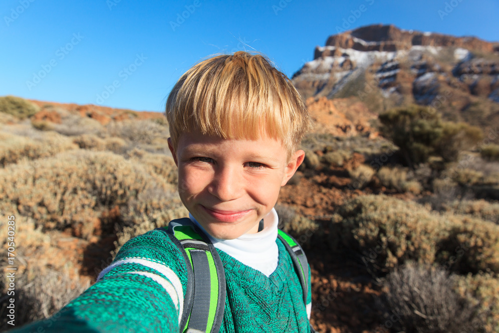 little boy making selfie while travel in mountains