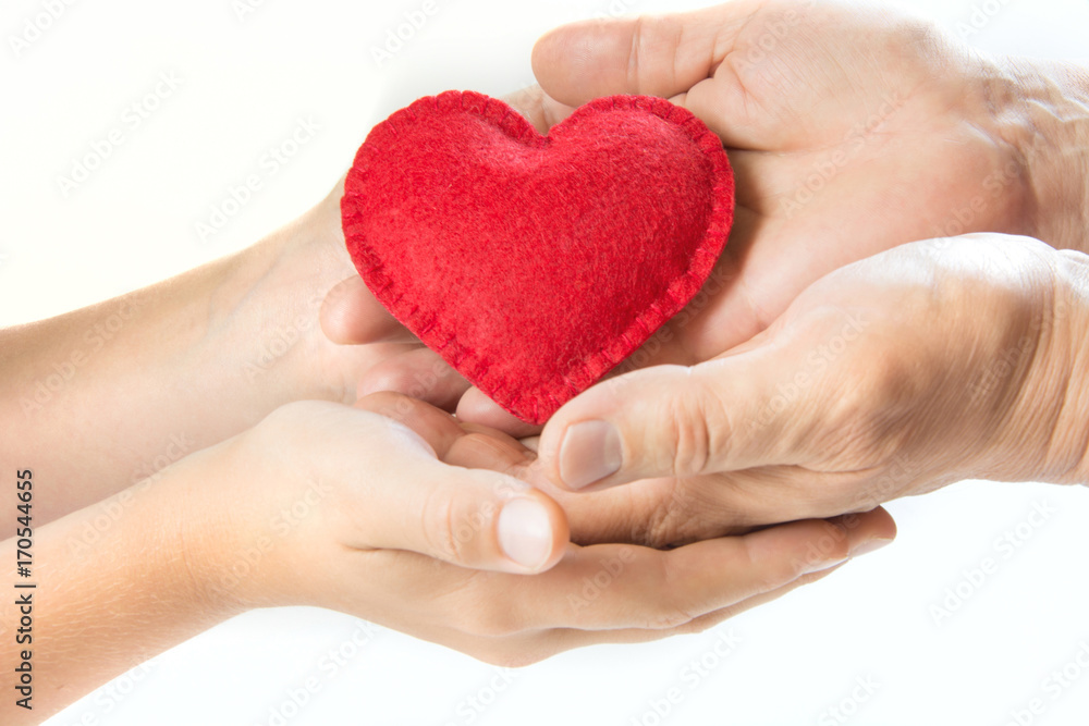Obraz premium Red felt heart in childs and mens hands on white background. View from above. Copy space.