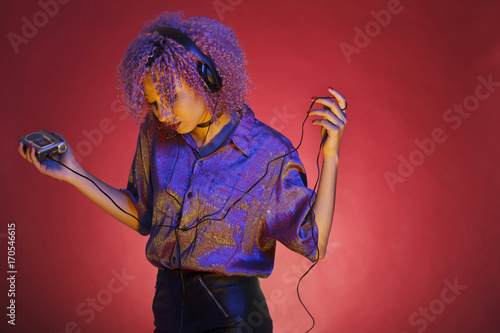 Tableau sur toile young afro american woman listening to music from her retro walkman